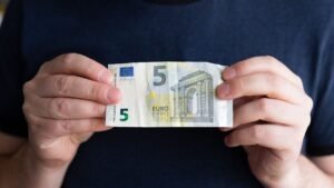 billet 5 euros dans la main